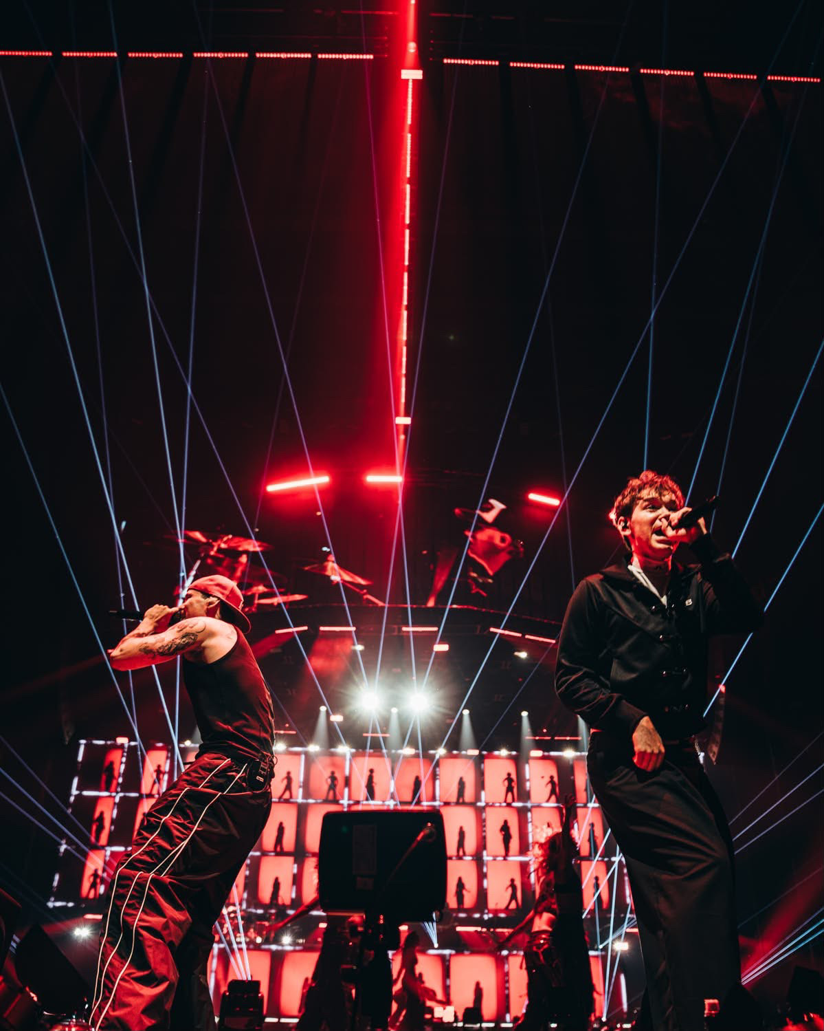 Marcus & Martinus singing under red beams and blue lasers on stage