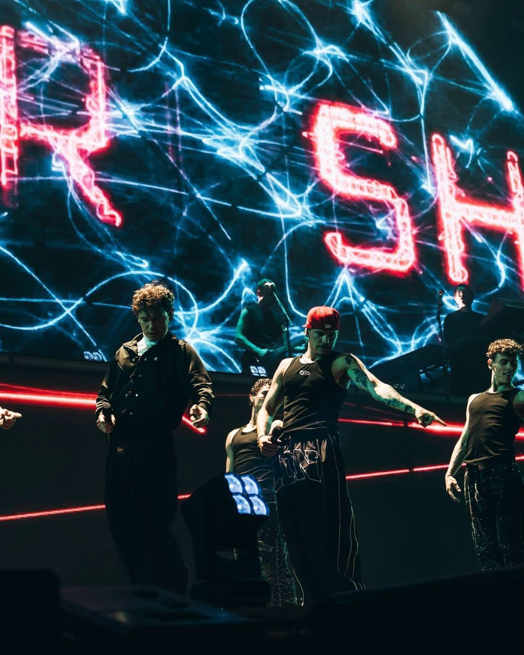 Marcus & Martinus dancing with their dancers in front of a glowing blue screen