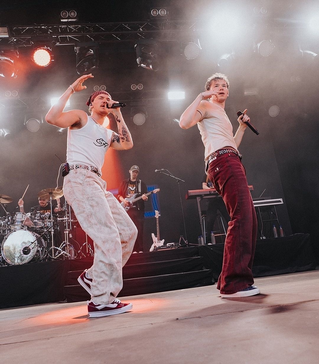 Marcus & Martinus singing with their live band behind them on stage